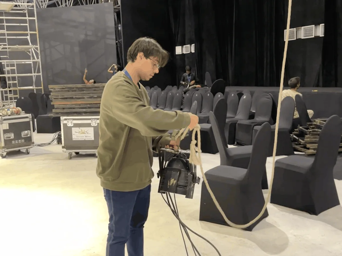 IIED lighting student rigging a PAR light during show setup